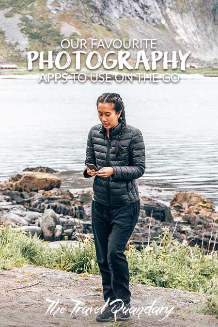 A girl dressed in black checks her phone after taking a photo in Lofoten, Norway