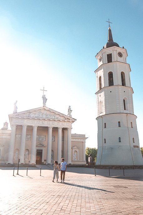 A couple crossing the road in front of Vilnius Cathedral, Vilnius Lithuania