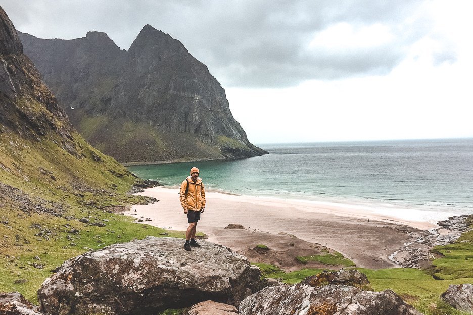 Bevan standing on a rock with Khalika Beach in the background - Lofoten Islands, Norway
