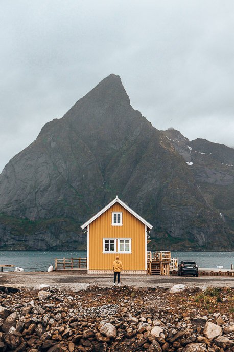 Bevan matching in his yellow coat with the yellow house in Hamnoy - Lofoten Islands, Norway