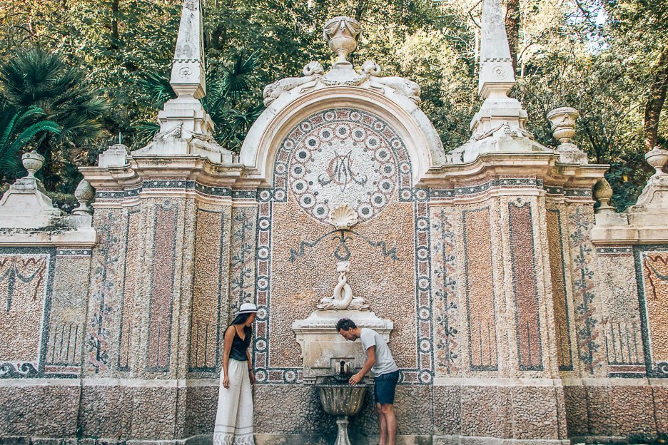 A couple stand in front a mosaic decorated water fountain in Sintra - 5 Things When Dating Travelling