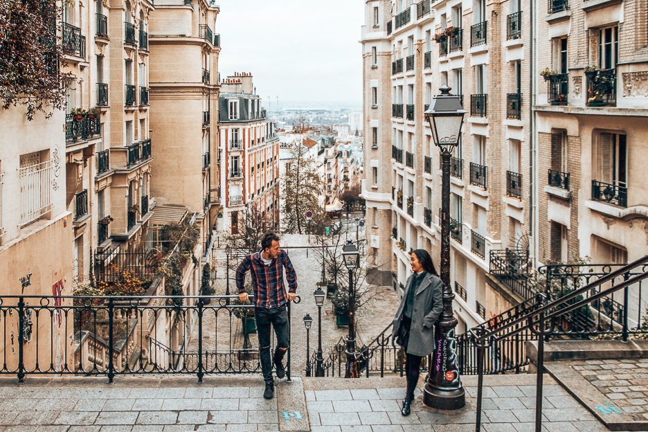 A couple standing at the top of the stairs in Montmartre, Paris - Travelling with Parents
