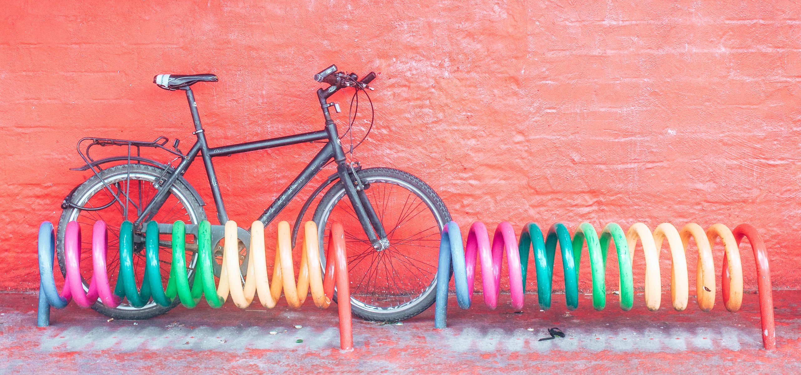 A bicycle against colourful coils and red wall, Copenhagen Denmark