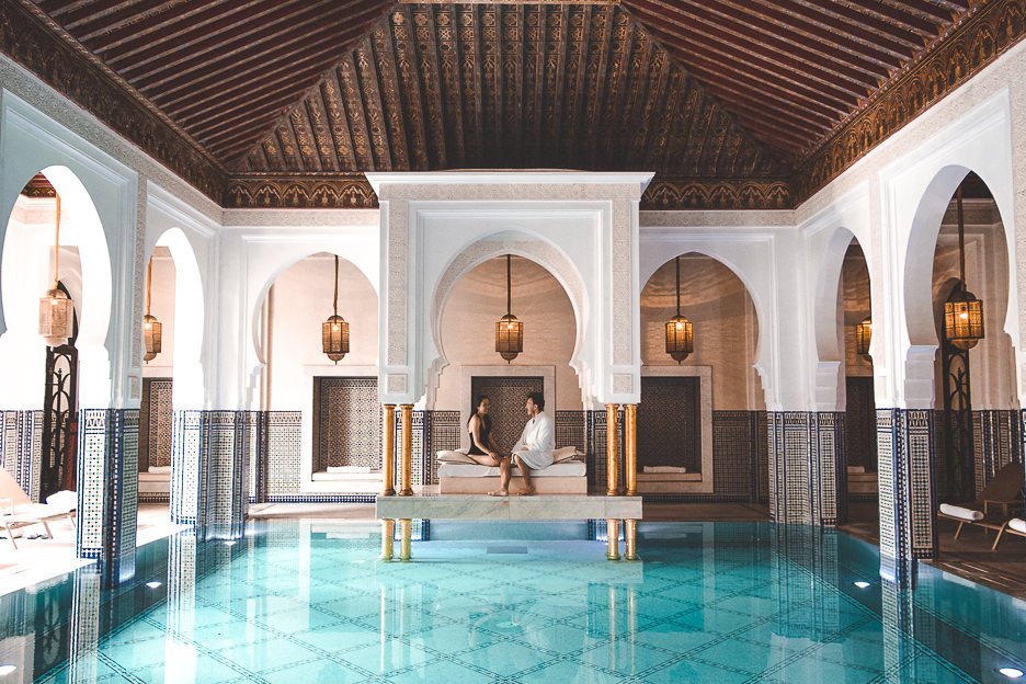 A couple sit on the day lounge in the indoor pool at La Mamounia, Marrakech, Morocco