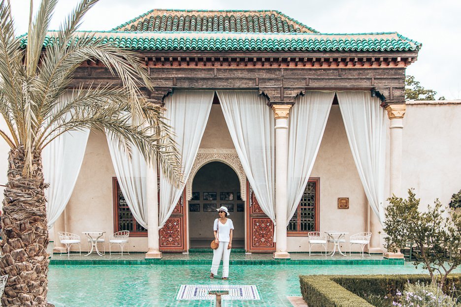 Jasmine stands on green tiles in between the white curtains of le Jardin Secret, Marrakech, Morocco