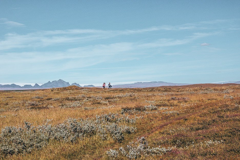 Campers wander through grassy plains, Iceland