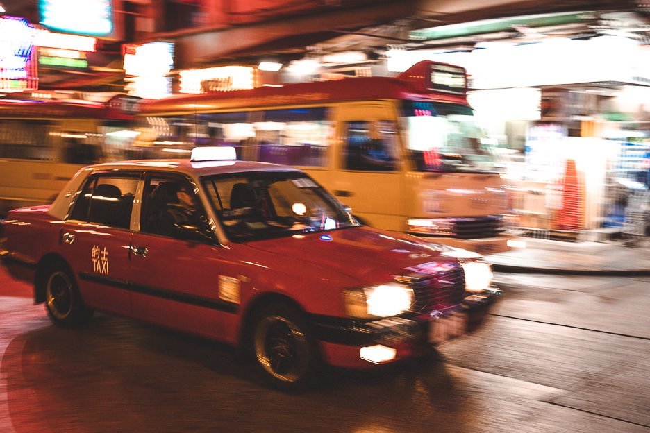 The blur of a red taxi and public light bus in Mong Kok, Hong Kong