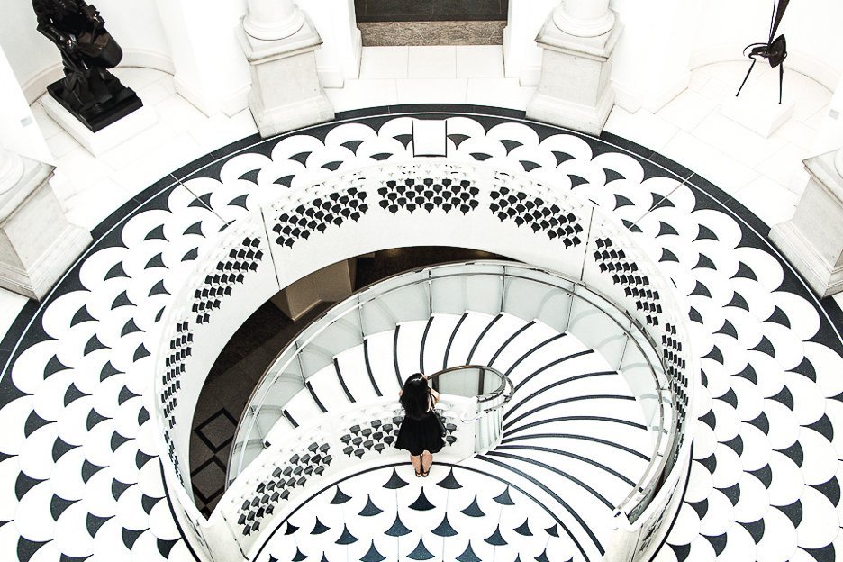 Jasmine of The Travel Quandary stands on top of the black and white marble staircase inside the Tate Britain in London - United Kingdom
