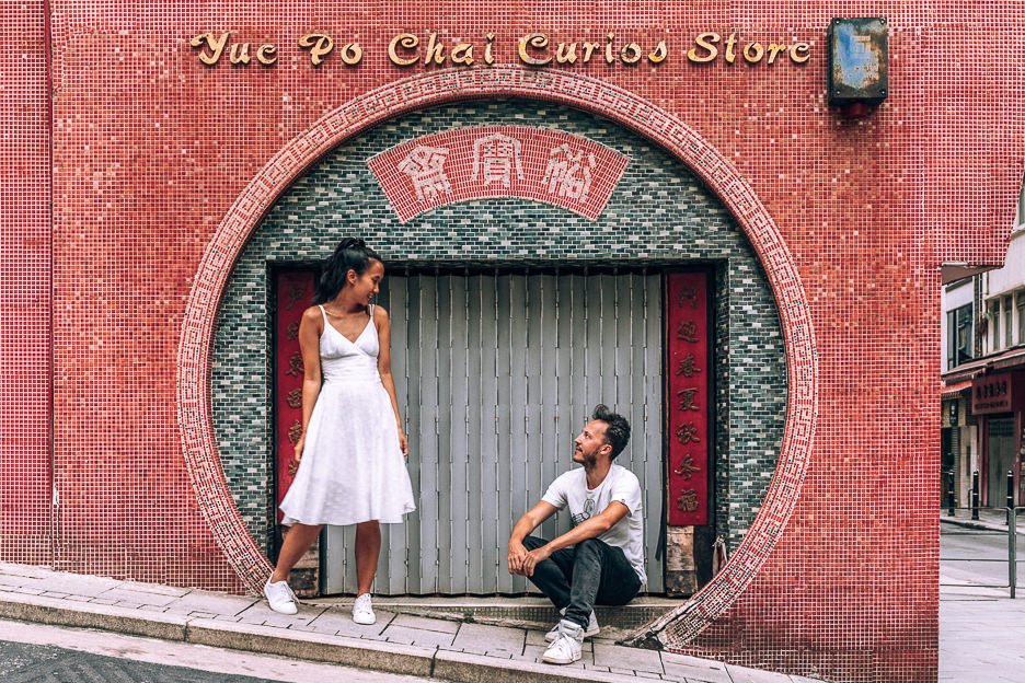 a couple pose in the circular archway of Yue Po Chai Curios Store, Hong Kong