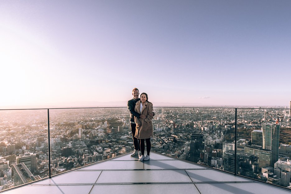 A couple pose at the edge of Shibuya Sky Observation Deck at sunset | Shibuya what to do