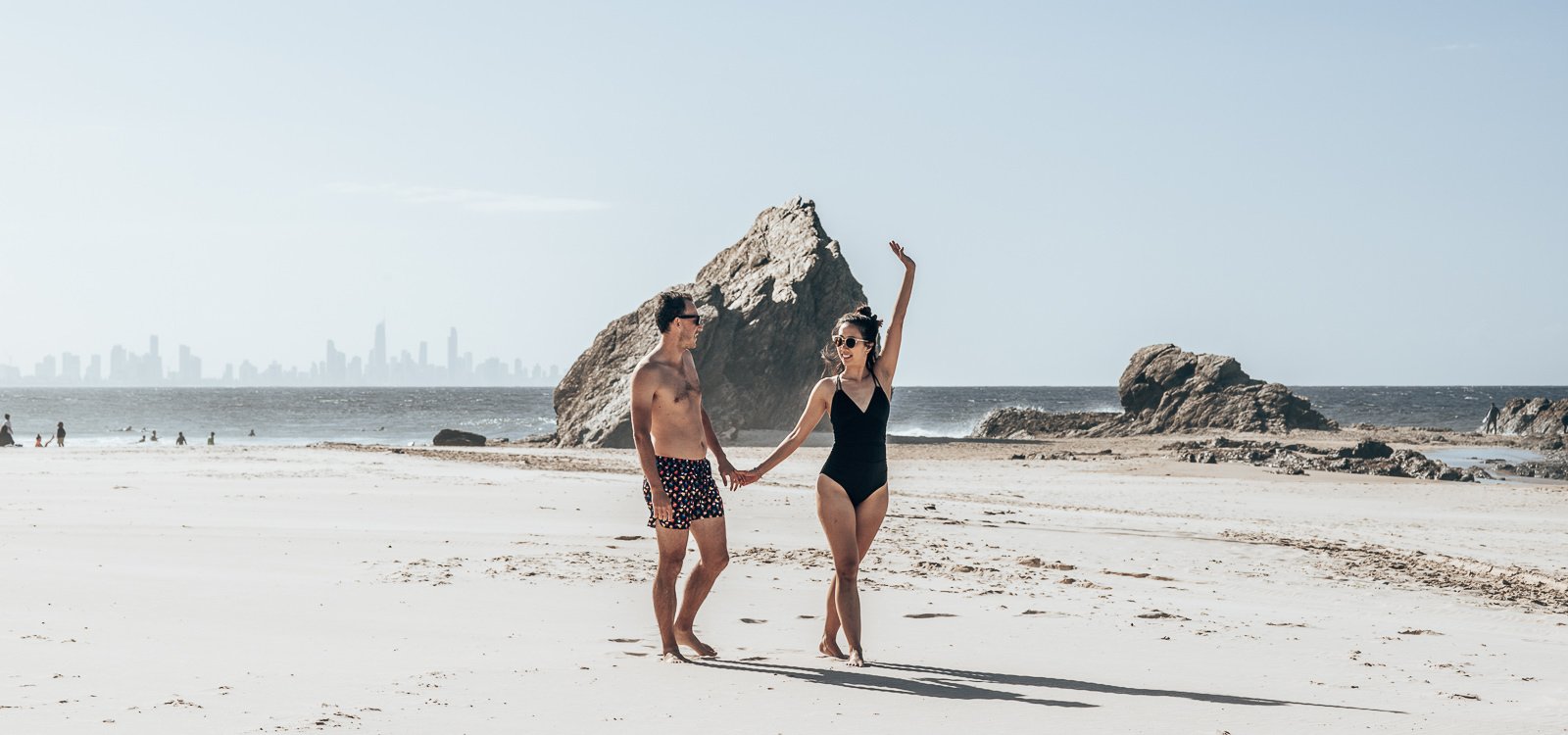 A couple walk hand in hand along Currumbin Beach, Gold Coast Australia